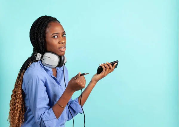 レトロな有線ヘッドフォンを持つアフリカ系アメリカ人の若い女性. — ストック写真