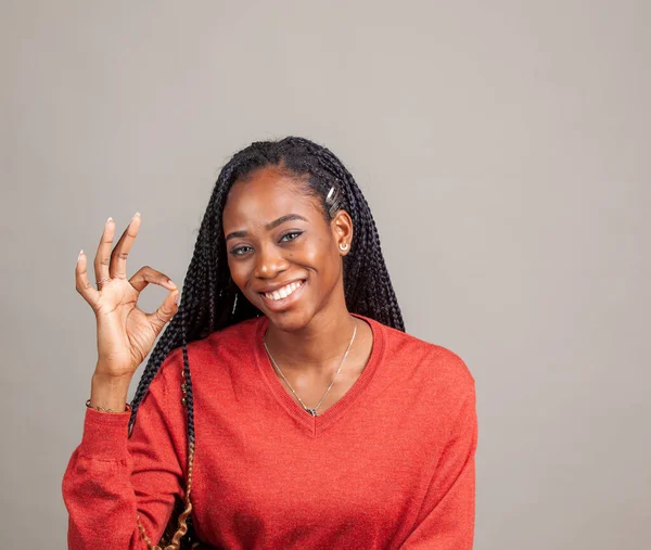 X Happy, positive African American female in red color shirt on gray background. — Stock Photo, Image