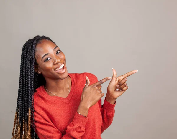 X Mujer afro-americana feliz y positiva en camisa de color rojo sobre fondo gris . —  Fotos de Stock