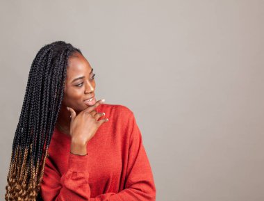 X Happy, gri arka planda kırmızı gömlekli Afro-Amerikan kadın. 