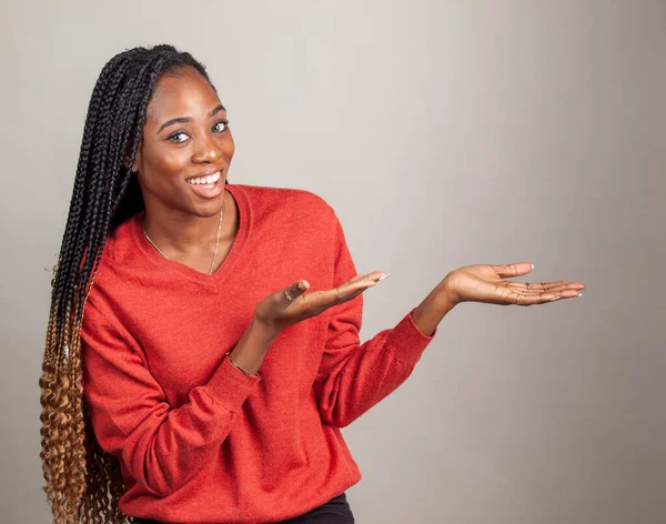 X Happy, positive African American female in red color shirt on gray background. — Stock Photo, Image