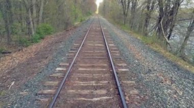 Bahar zamanı büyük bir nehrin yanındaki eski demiryolu raylarından geçmek..