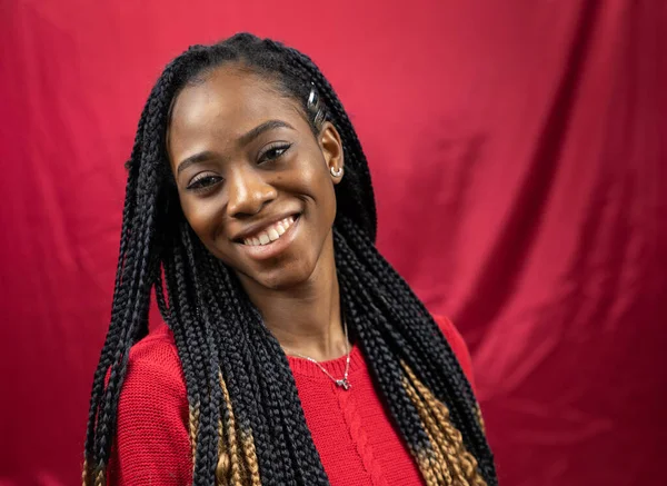 Attractive, smiling African American female in red color shirt on red background. — Stock Photo, Image