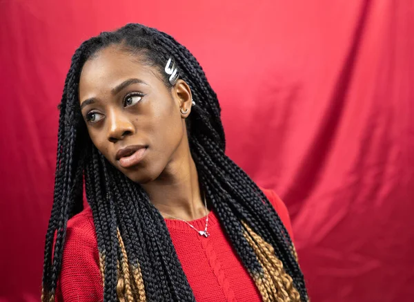 Attractive, serious African American female in red color shirt on red background. — Stock Photo, Image