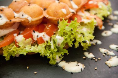 Hong Kong waffle 'ı. Domatesli waffle salatası, mayonez ve susam tohumları serpiştirilmiş..