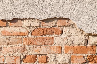 Tuğlalı ve alçılı eski duvarın arkaplanı.