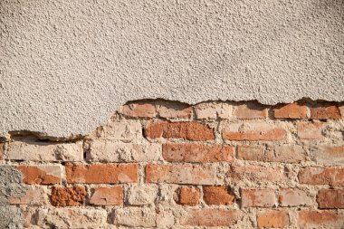 Tuğlalı ve alçılı eski duvarın arkaplanı.