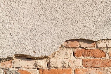 Tuğlalı ve alçılı eski duvarın arkaplanı.