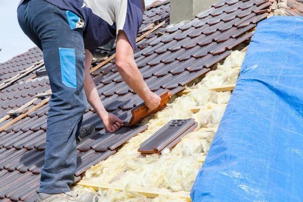 Roofer laying tile on the roof