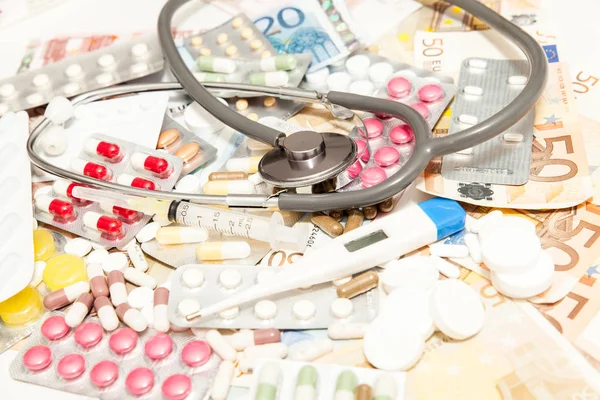 Medicamentos coloridos con dinero en la mesa — Foto de Stock