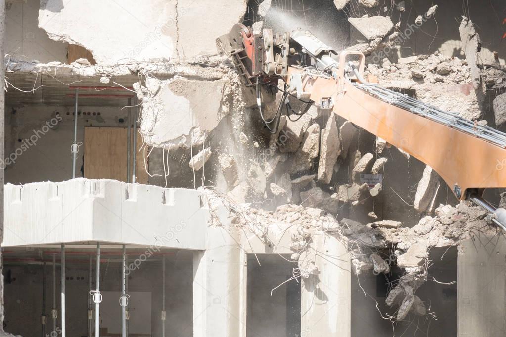 Demolition of concrete building with excavator 