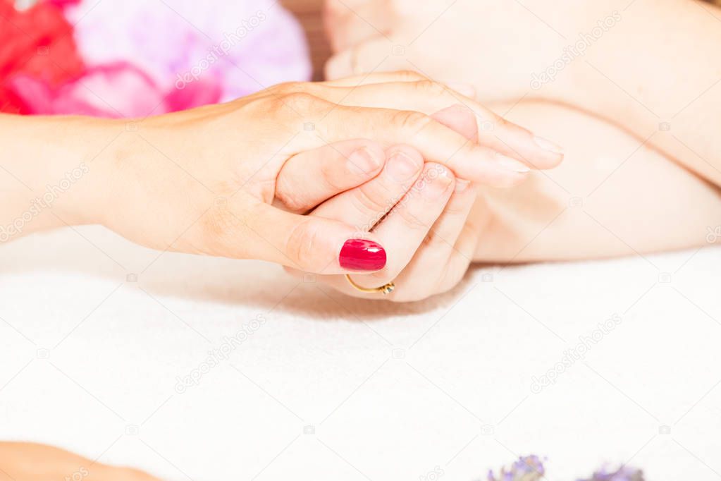 esthetician decorating nails of female client in salon 