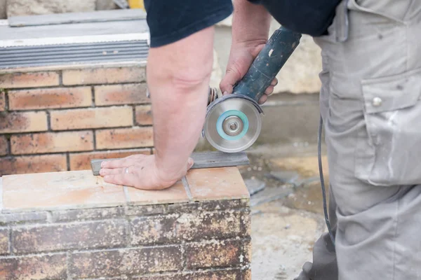 泥瓦匠用磨床切割瓷砖的施工现场 — 图库照片