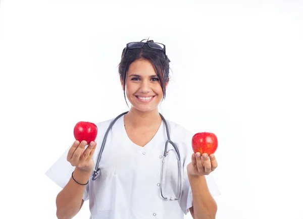 年轻的女医生露出两个漂亮的红苹果 — 图库照片