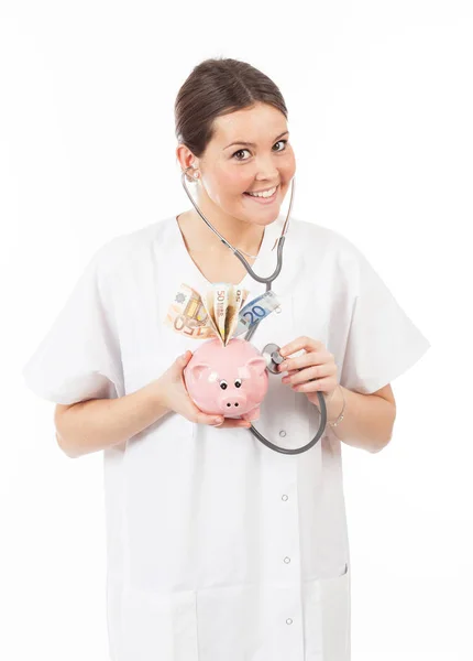 幸福的女人医生与储钱罐装满了钱 — 图库照片