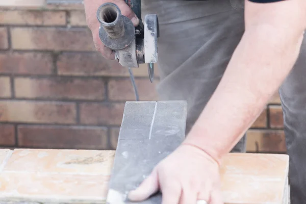Tiler cutting a tile with a grinder — Stock Photo, Image
