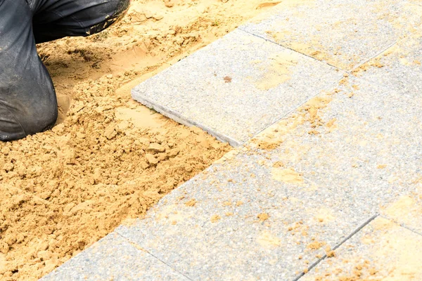 The mason lays gravel slabs on sand to make an alley — Stock Image The mason lays gravel slabs on sand to make an alley Royalty Free Stock Images