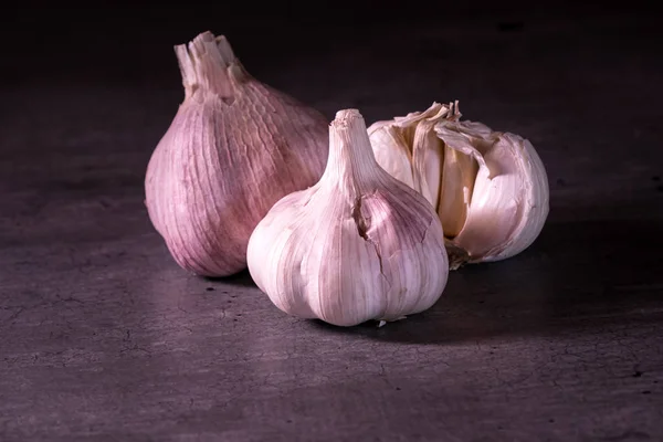 Tres grandes cabezas de ajo rosa en una encimera de cocina — Foto de Stock