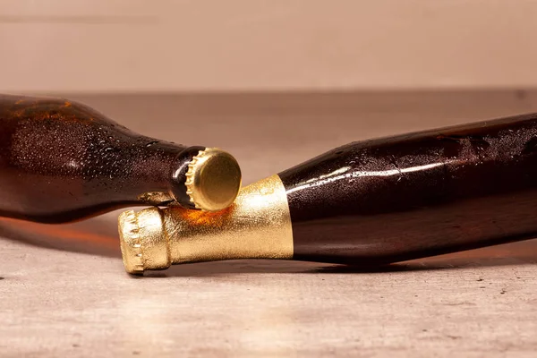 Una botella de cerveza rubia y una botella de cerveza ámbar tumbada —  Fotos de Stock