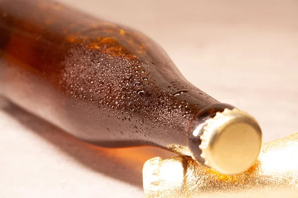Egy üveg sör borostyán fekszik a kapszulával — Stock Fotó