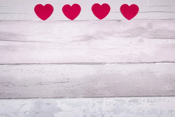 Red felt hearts on a background of old wooden planks resembling — Stock Photo, Image