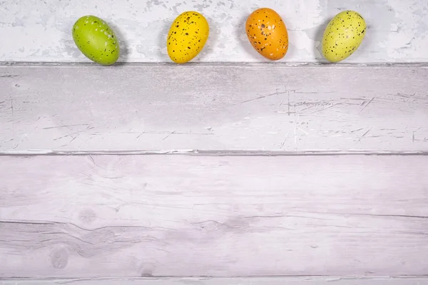 Oeufs de Pâques vert et jaune orangé sur un fond de vieux bois — Photo