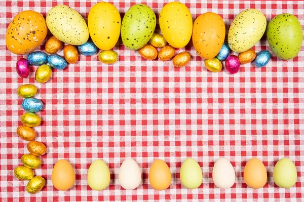 Mezcla de huevos de Pascua de todos los colores y tamaños sobre un fondo de re —  Fotos de Stock