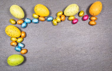 Gri granit arka planda her renk ve boyutta Paskalya yumurtası karışımı. Paskalya konsepti.