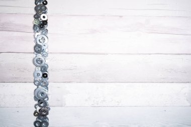 Eski ahşap arka planda farklı boyutlarda metal yıkayıcılar var. en üstteki görünüm.