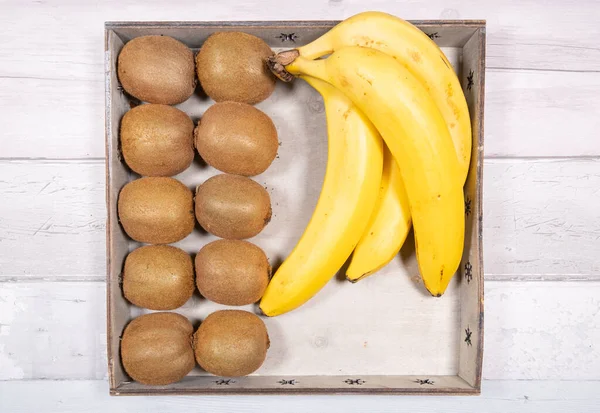 Bananen Und Kiwis Einem Alten Holztablett Auf Einem Hintergrund Aus — Stockfoto