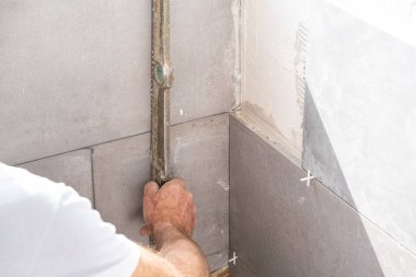 The tiler duvara seramik bir karo sergiler.