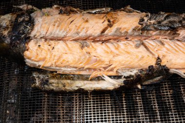 Izgarada mangal yapan otlarla doldurulmuş somon balığı.