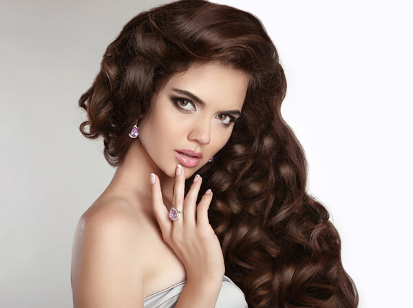 Brunette girl with long shiny wavy hair. Beauty makeup. Beautifu