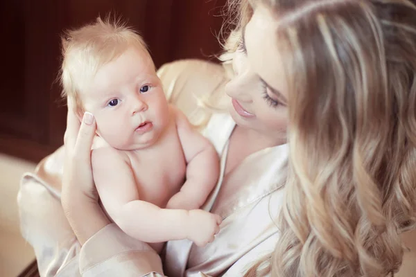 Entzückendes Babyporträt. glücklich schöne Mutter hält ihr Neugeborenes — Stockfoto