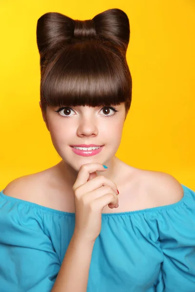 Ganska leende tonåring flicka med rosett frisyr, smink och rummen — Stockfoto