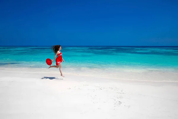 Красива вільна молода жінка стрибає на екзотичному морі, щаслива брюнетка — стокове фото