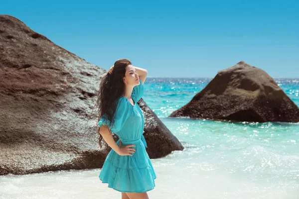 Femme brune insouciante en robe bleue profitant de la vie près du littoral — Photo