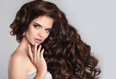 Sağlıklı kıvırcık saçlı. Güzel esmer kadın modeli makyaj ile, 