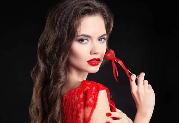 Los labios rojos. Hermosa chica morena retrato sosteniendo regalo de corazón fo — Foto de Stock