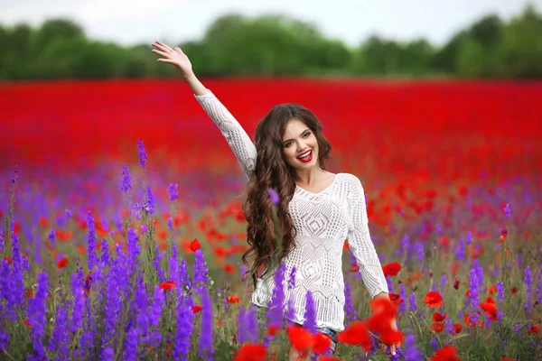 Beautiful young woman portrait in poppies field. Attractive brun — Stock Photo, Image