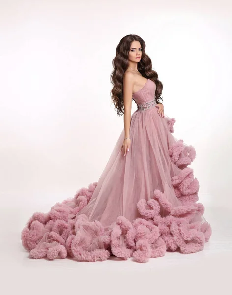 Moda morena mujer en magnífico vestido largo rosa posando aislado — Foto de Stock