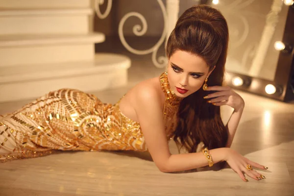 Elegant fashion brunette woman in luxury golden dress. Hair styl — Stock Photo, Image