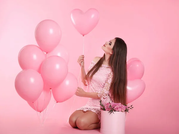 Симпатичная брюнетка с воздушными шарами и букетом розы — стоковое фото