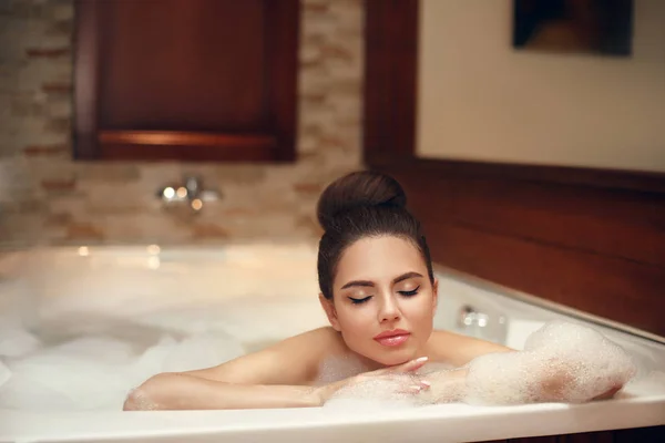 Mujer joven relajante en spa jacuzzi de espuma, morena disfrutando —  Fotos de Stock