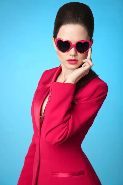 Fashionable trendy brunette wearing in heart sunglasses and red — Stock Photo, Image