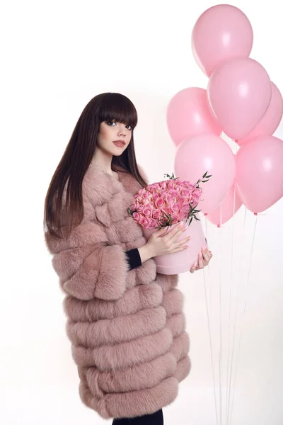 Young brunette girl in pink fur coat with rose bouquet of flower — Stock Photo, Image