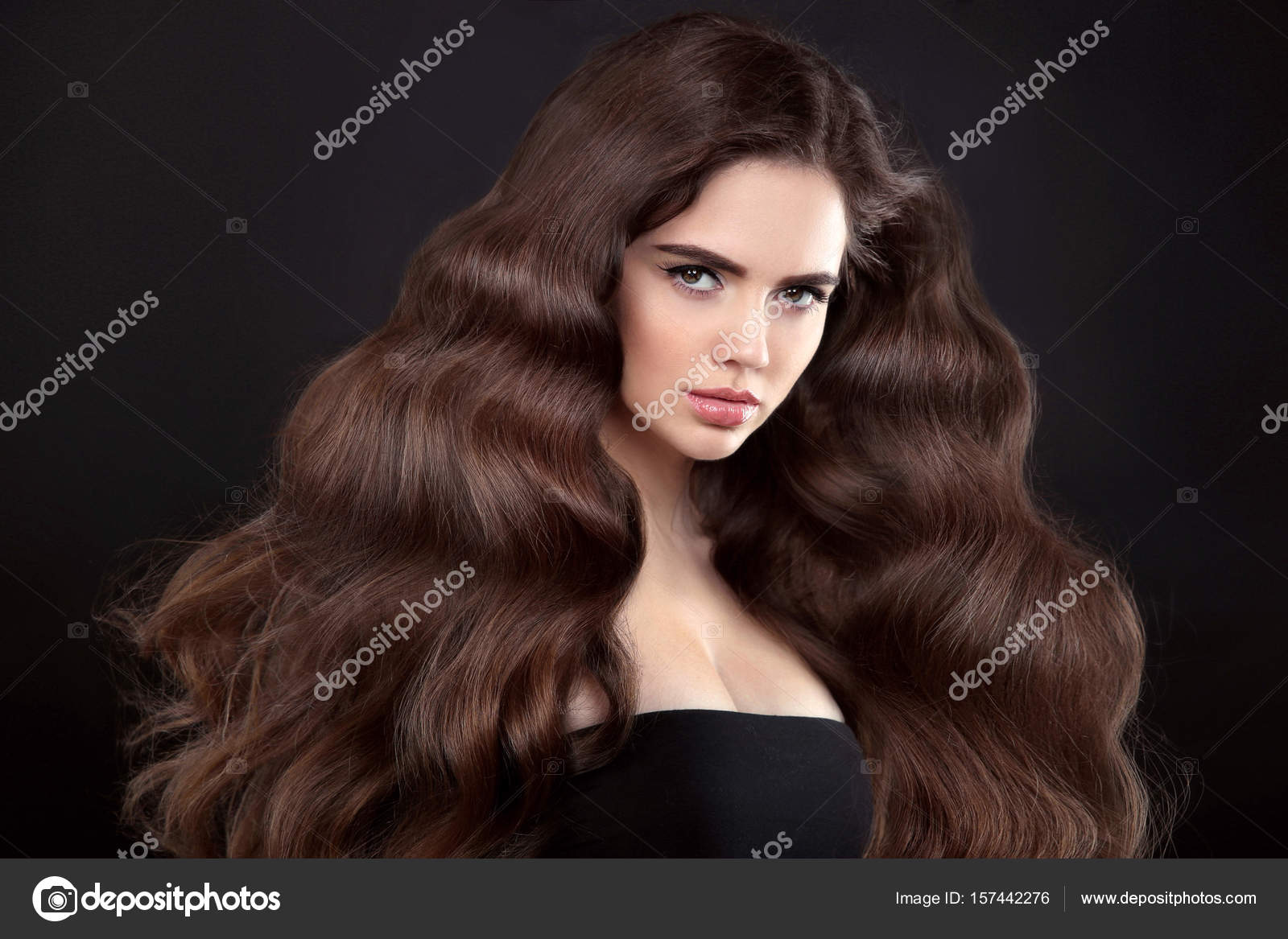 Cabelo. linda garota com cabelo longo ondulado e brilhante. mulher morena  com penteado encaracolado lindo. cuidado capilar. cabelo comprido saudável.  mulher modelo de beleza. cabelo castanho.