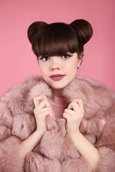 Coiffure de chignon de beauté. Mode adolescent fille modèle en manteau de fourrure rose . — Photo