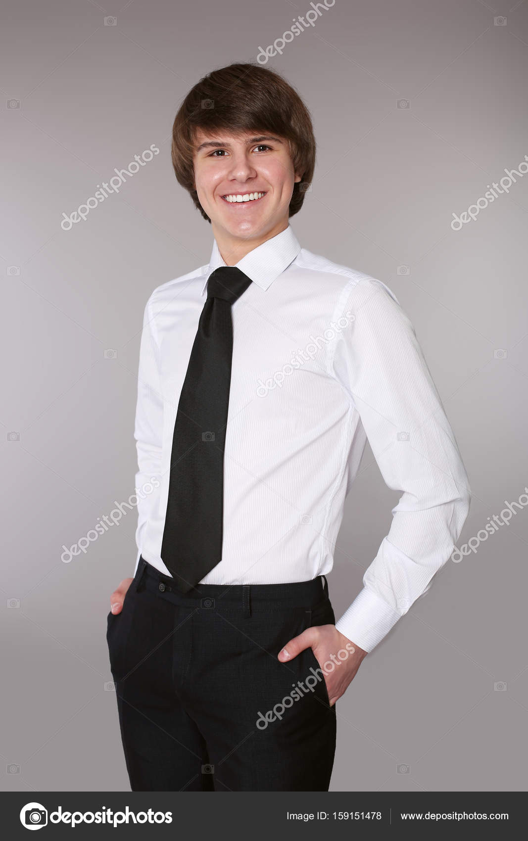 Hombre guapo en camisa blanca con corbata negra manteniendo las
