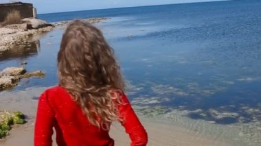 Kadın çalışan el sahilde deniz rüzgarda üfleme kıvırcık saçlarının arasından portresi kapatın. Mavi gökyüzü üzerinde mutlu erkek.